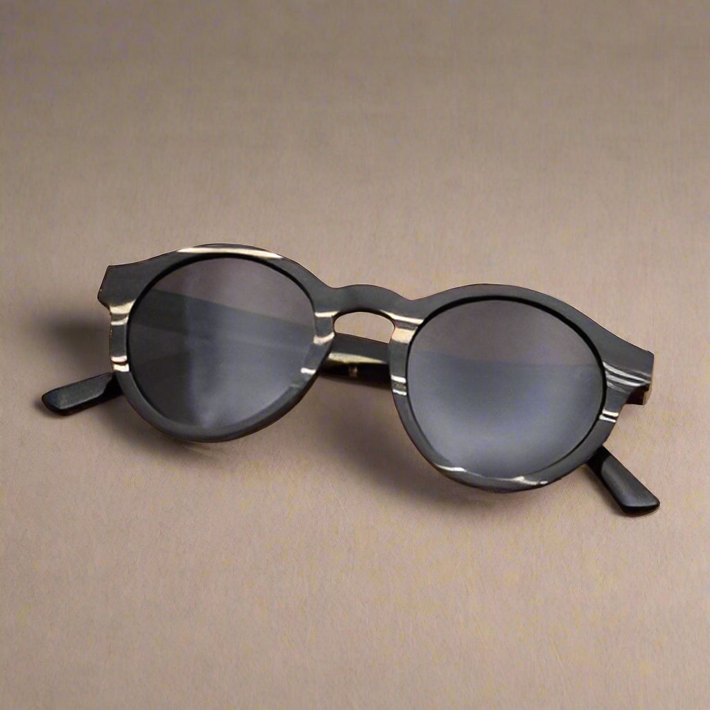 Sunglasses on a wooden surface with autumn leaves